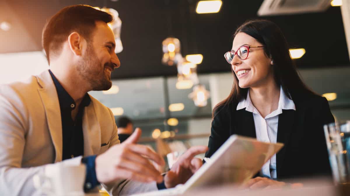 Zwei Menschen in Business-Outfit sitzen am Tisch mit Laptop und lachen sich an. Die Atmosphäre ist locker und fröhlich. Der Hintergrund ist unscharf. - Bild von dusanpetkovic1 (Adobe Stock) Zwei Menschen in Business-Outfit sitzen am Tisch mit Laptop und lachen sich an. Die Atmosphäre ist locker und fröhlich. Der Hintergrund ist unscharf.
