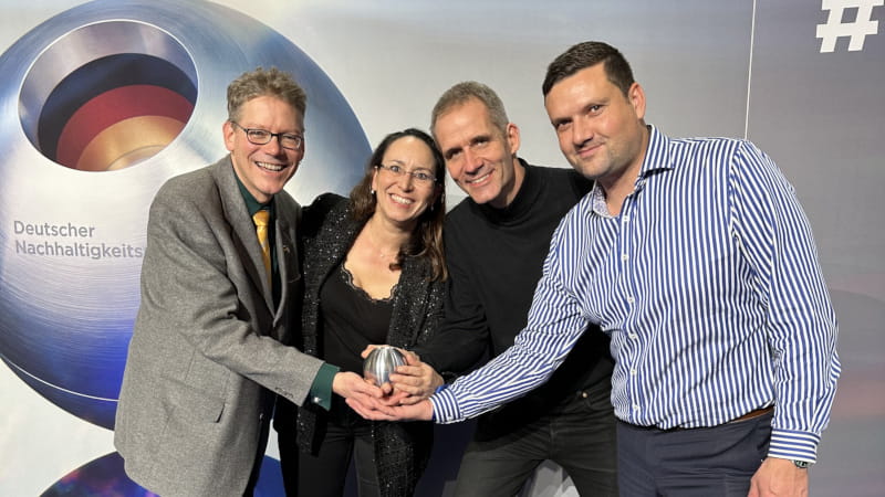 Das greenjobs-Team - vier Personen - hält den Deutschen Nachhaltigkeitspreis in den Händen.